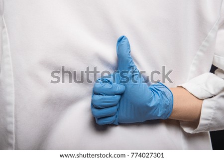 Close-up of doctor making like gesture on the back on black background