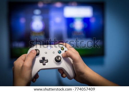 Debrecen, Hungary, 19. November 2017 View from the top on xbox one s gamepad, game console, kid holding in his hands Royalty-Free Stock Photo #774057409