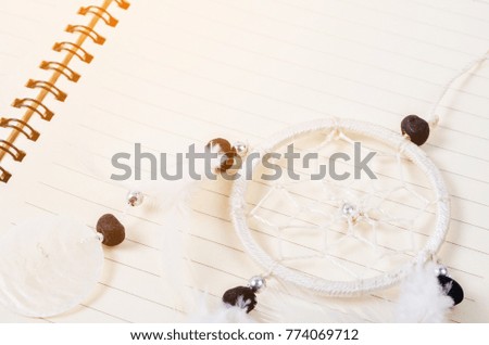 White dream catcher on open diary page.