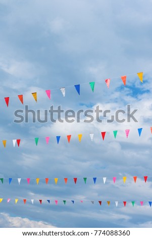 image of festival flag line with cloudy sky in background on day time .(vertical)
