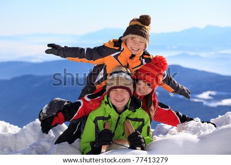 Happy young boys and girls on summit of snowy mountain in Winter.