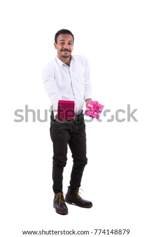 Full-length image of a smiling guy wearing white shirt, black trousers, and boots showing empty pink gift box. Isolated on white background.