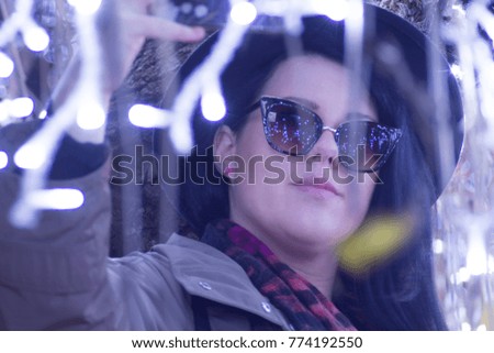 Celebration concept - Merry Christmas and happy New Year - Young woman taking a selfie outdoor in night, bokeh lights