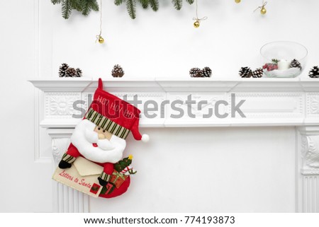 A close picture of beautifully decorated Santa Christmas socks with ho! ho! ho! word hanging on a fireplace waiting for presents.