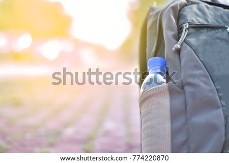 Lifestyle Travel outdoor with Bottle water in Bag placed on the floor and natural light.