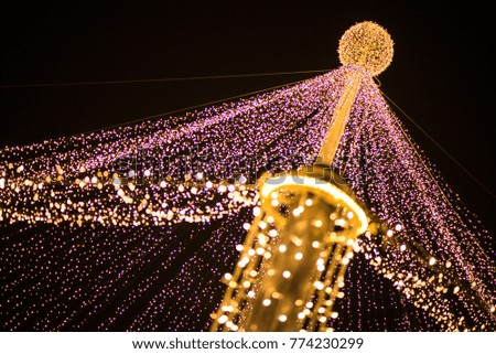 Abstract Christmas tree, colorful, blurry background. Glowing and sparkling lights in city center in Christmas market
