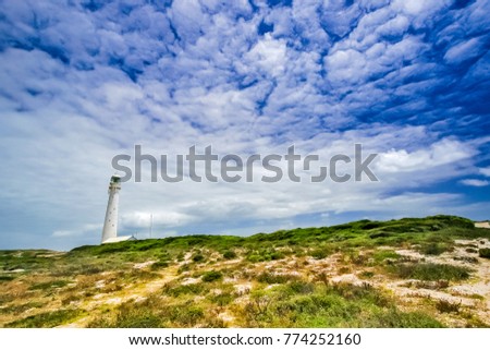 Fish eye view of Lighthouse on the shoreline; Rocky coastline; windy day at the beach; Rugged coastline