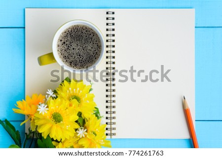 top view coffee cup and notebook on blue wooden table nature background the good morning .decorate flower