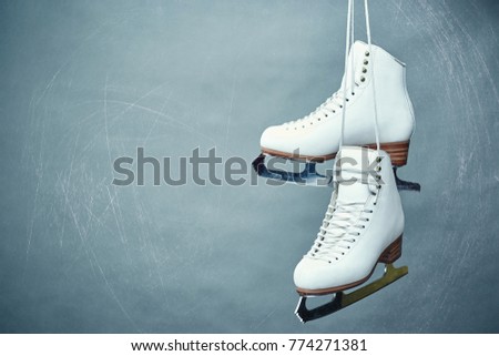 A pair of female white skates on a gray background.