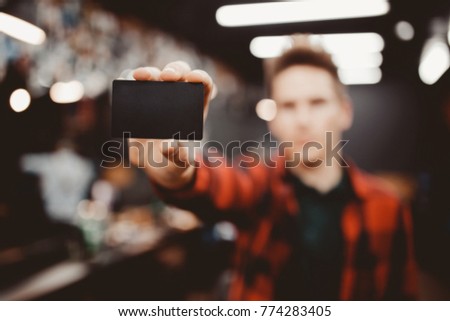 Barber shop. Close-up of man holds business card, certificate space for customers. Copyspace