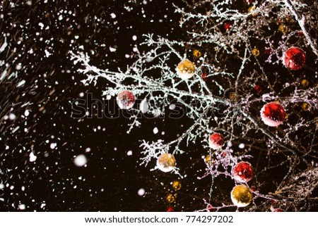 evening snowfall, decoration of the streets in front of the Christmas balls on the trees