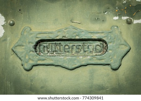 Old rusty mailbox with the word "letters" in Spanish "cartas"