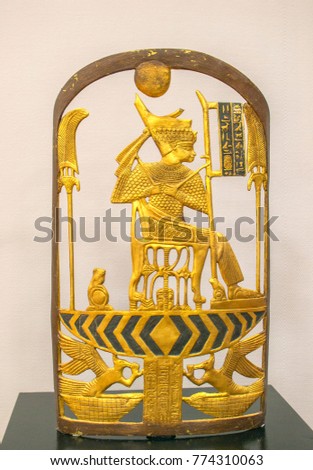 Ancient Egypt open shield with sitting pharaoh, 16 century BC, gilded wood. Selective focus