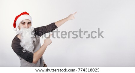 The man in santa hat and with white beard pointing on something on the left size