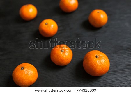 Tangerines on a black background. Lots of fresh fruit - mandarins. High quality photo