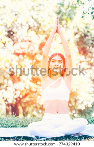 Beautiful young asian girl doing yoga in the garden, Selective focus used for background. Peaceful Meditation for good health in the park.Time for practicing yoga concept, Wellness concept. 