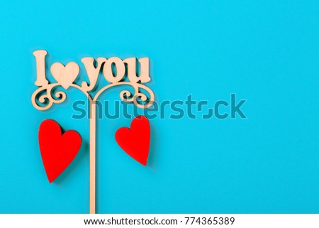 Valentine day concept. Inscription I love you with red decorative hearts on blue background. Free space for your text