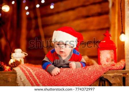 Baby first christmas. Beautiful little baby boy celebrates Christmas, New Year's holidays.Cute Toddler playing and smilingnear gifts, tinsel, balls and christmas tree