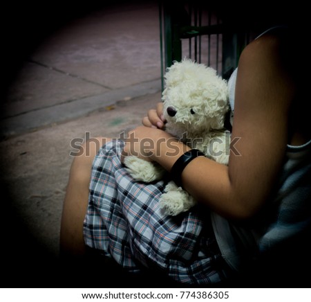 Sad child. Child hugging doll sitting sad.