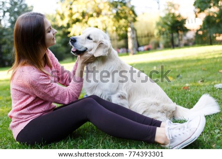 Picture of brunette hugging labrador on lawn