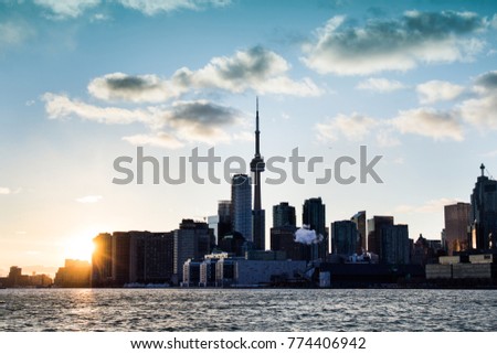 Toronto city skyline/downtown cityscape with sun burst from edge of downtown buildings. Winter/cool urban landscape. Toronto, Ontario, Canada
