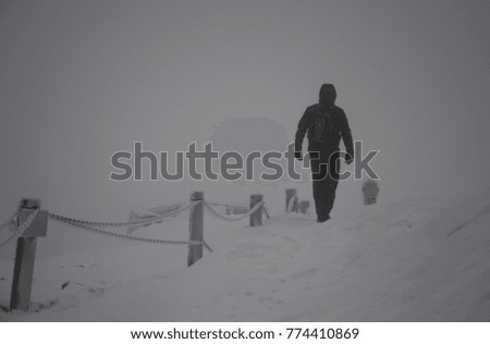 Unknown man walking on a road in a cold winter