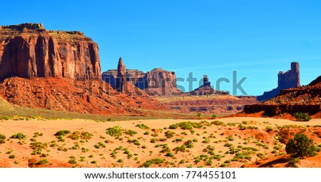 Monument Valley is a region of the Colorado Plateau characterized by a cluster of vast sandstone buttes above the valley floor. It is located on the Arizona-Utah state line, USA Royalty-Free Stock Photo #774455101