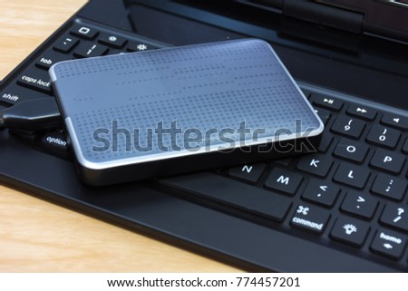 
External hard disk on laptop. 
External hard drive on keyboard.