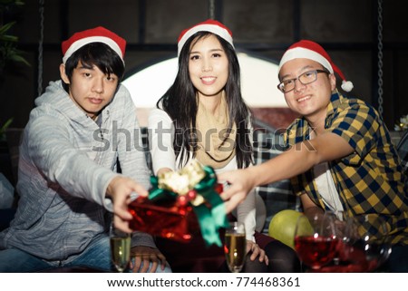 Picture group of friends in Santa hats showing Christmas Gift