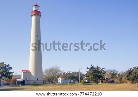 Exterior daytime stock photo of lighthouse at edge of field in Cape May, New Jersey in Cape May County on winter December afternoon with blue cloudless sky in background