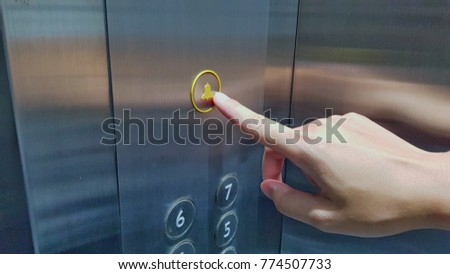 Hand of a man press the help signal inside the elevator