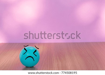Sadness blue ball on wooden table with bokeh wall background and copy space