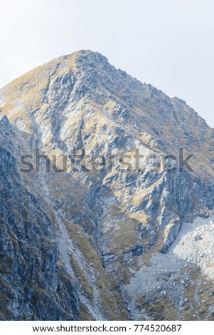 rocky mountain peak area view in slovakia. bright sunlight and white clouds on blue sky covering hills. panoramic view - vintage look