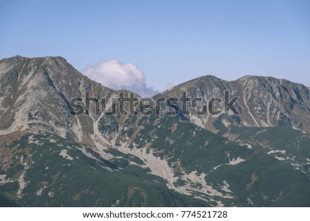 Tatra mountain peak view in Slovakia in sunny day. blue sky with clouds above - vintage retro film look