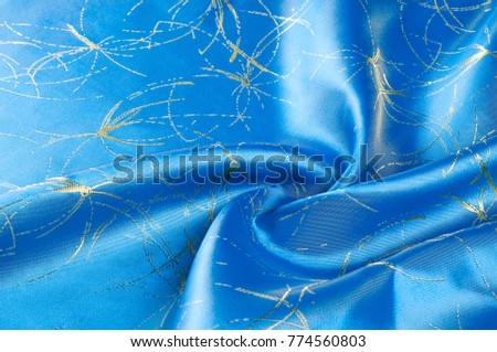 Background texture, pattern. Fabric blue silk with gold pattern. 