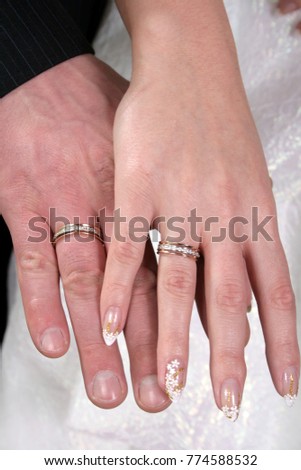 Hands of the groom and the bride with wedding rings