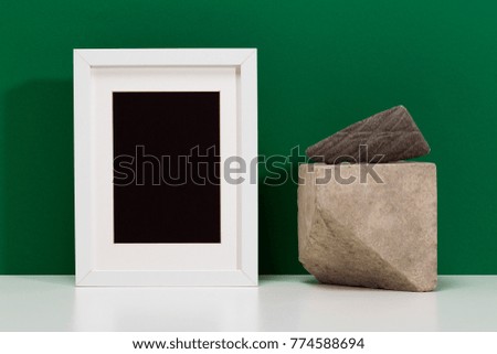 Blank white frame template for mock up and stone sculpture. Home decor composition