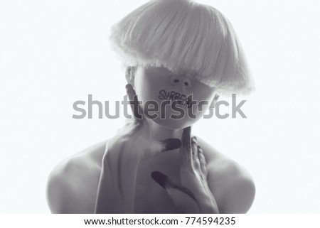 A girl with white skin and a white wig with an inscription on her lips 'surreal'.
