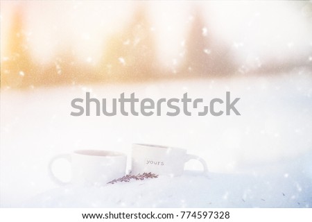 Winter picture with two cups with mulled wine in the snow. Holiday concept.