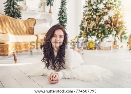Elegant lady in white dress over christmas tree background. happy new year