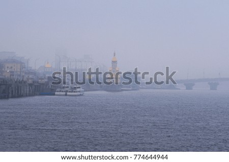 Misty winter morning. View to the embankment near the river port. City landscape. Kyiv, Ukraine.