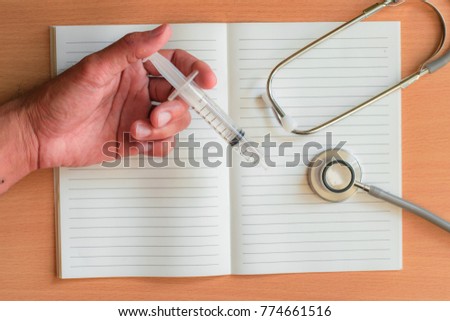 Notepad with stethoscope and pencil on wood board background.using wallpaper for education, business photo.Take note of the product for book with paper object, concept or copy space.