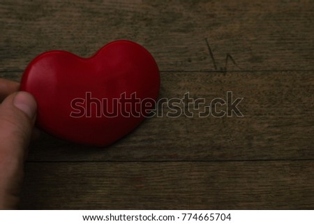 Red heart symbol of love on a wooden table.