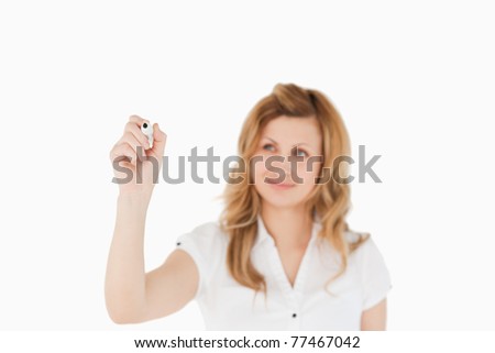 Blond woman drawing a scheme looking towards the camera on a white background