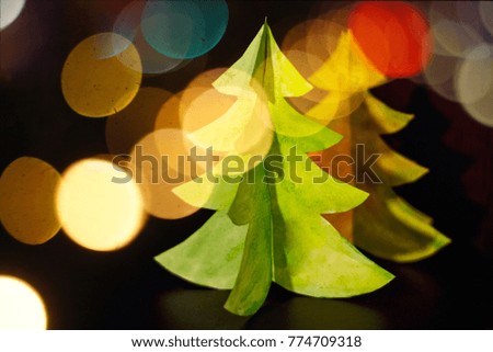 Christmas Holiday Background,handmade modern christmas tree made of paper on bokeh background.Closeup.Greeting card.Creative Christmas tree.New Year Frame for your text. Hobby concept
