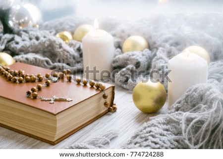 Christmas background with candle, wood cross, and string of holiday lights; Christmas religious background
