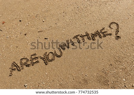 Handwriting  words "ARE YOU WITH ME?" on sand of beach.