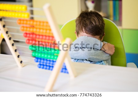 Angry toddler boy making a tantrum refing to play with abacus. Concentration deficit. Early child development. Royalty-Free Stock Photo #774743326