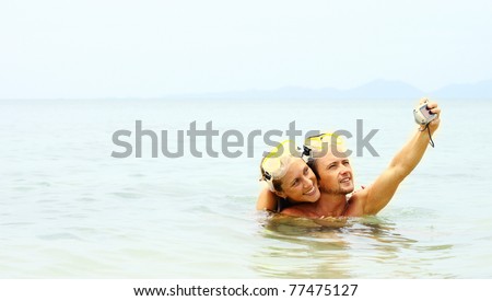Young man and woman taking the picture of them self in the sea