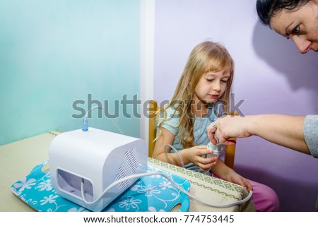 Woman is preparing inhalation treatment for child with asthmatic problems.